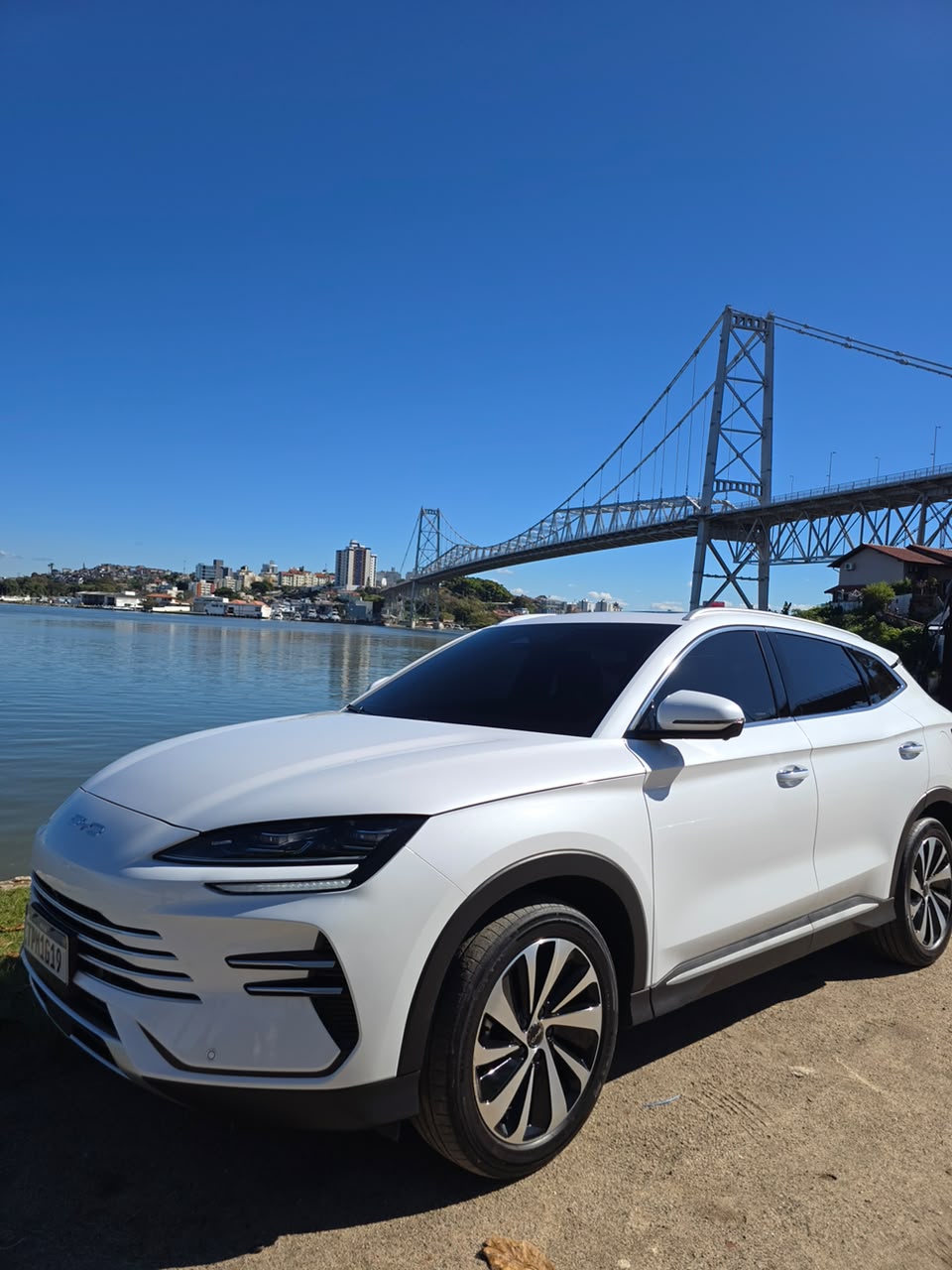 SUV executivo branco Douglas Transfer diante da Ponte Hercílio Luz em Florianópolis