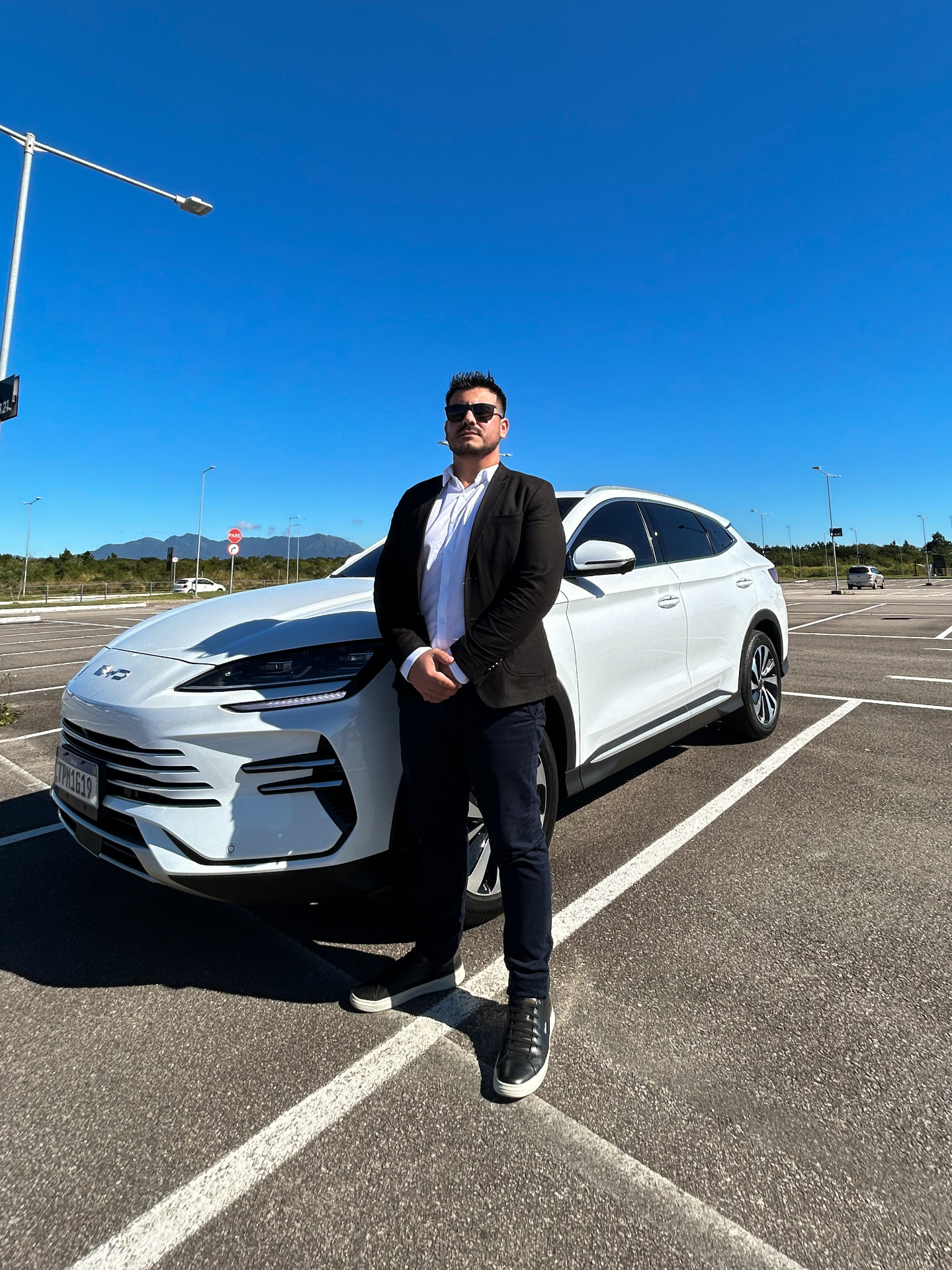 Motorista executivo da Douglas Transfer ao lado do SUV branco em Florianópolis